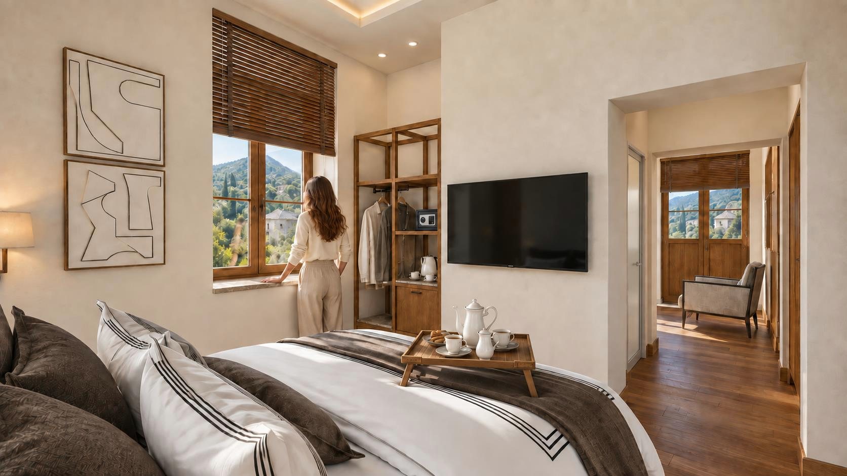 A bedroom with a tray of tea on the bed and a view of the village through the window